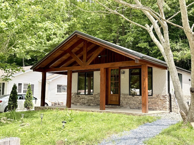 153 Hampton Creek Rd, Roan Mountain, TN 37687 - view of front of property with stone siding, stucco siding, a porch, and a front yard