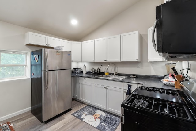 2087 Fodderstack Mountain Loop, Greeneville, TN 37745 - kitchen with freestanding refrigerator, a sink, lofted ceiling, light wood-type flooring, and gas range