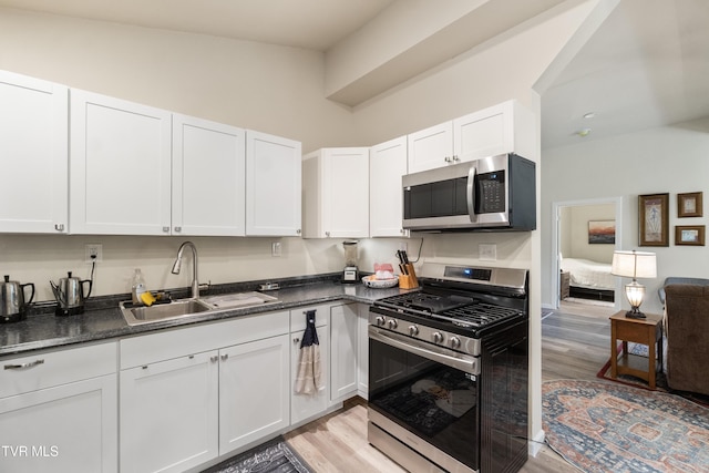 2087 Fodderstack Mountain Loop, Greeneville, TN 37745 - kitchen featuring appliances with stainless steel finishes, a sink, light wood finished floors, and white cabinets
