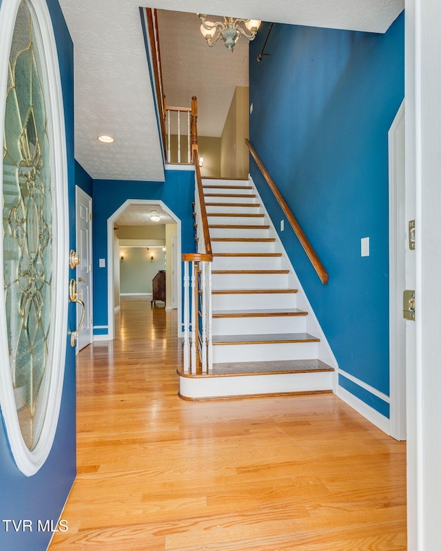 516 Bowmantown Rd, Telford, TN 37690 - entryway with wood finished floors, stairs, baseboards, arched walkways, and a chandelier