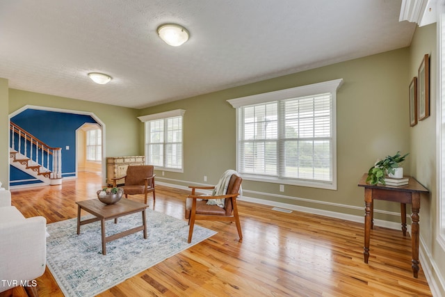 516 Bowmantown Rd, Telford, TN 37690 - living room featuring stairway, light wood-type flooring, baseboards, and a textured ceiling