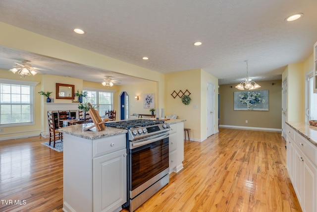 516 Bowmantown Rd, Telford, TN 37690 - kitchen featuring stainless steel range with gas stovetop, a ceiling fan, plenty of natural light, light wood-type flooring, and a textured ceiling