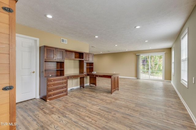 516 Bowmantown Rd, Telford, TN 37690 - unfurnished office with light wood finished floors, built in desk, recessed lighting, baseboards, and a textured ceiling