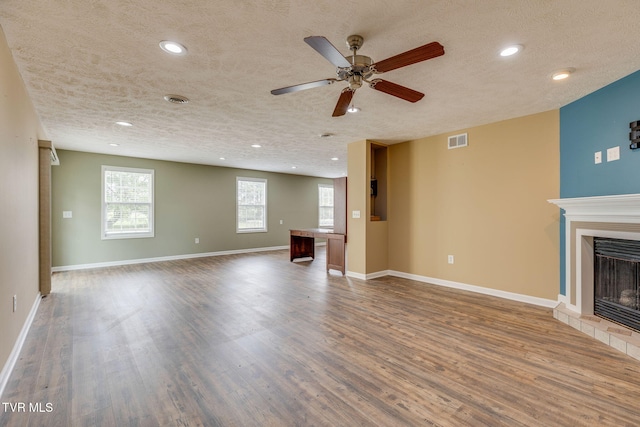 516 Bowmantown Rd, Telford, TN 37690 - unfurnished living room with a textured ceiling, a tile fireplace, wood finished floors, recessed lighting, and a ceiling fan