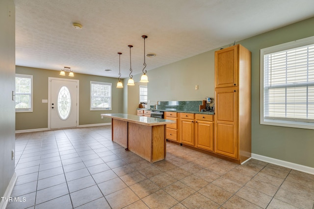 516 Bowmantown Rd, Telford, TN 37690 - kitchen with a kitchen island, light tile patterned flooring, baseboards, and hanging light fixtures