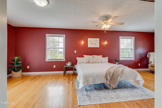 516 Bowmantown Rd, Telford, TN 37690 - bedroom with multiple windows, a textured ceiling, baseboards, wood finished floors, and a ceiling fan