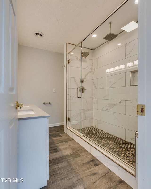 516 Bowmantown Rd, Telford, TN 37690 - bathroom featuring a marble finish shower, wood finished floors, baseboards, a textured ceiling, and recessed lighting