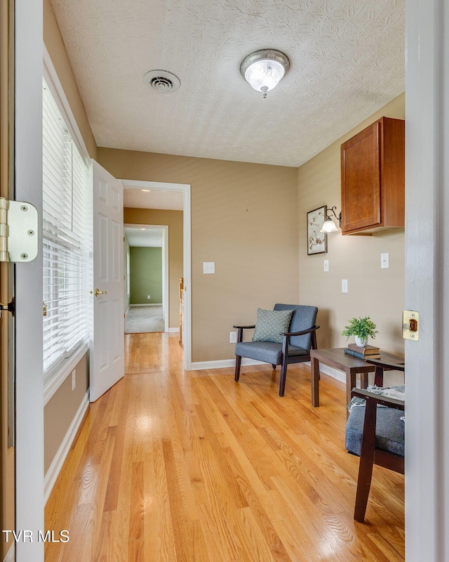 516 Bowmantown Rd, Telford, TN 37690 - living area with light wood-type flooring, a textured ceiling, and baseboards