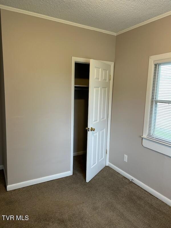 1657 Redwood Dr, Kingsport, TN 37664 - unfurnished bedroom featuring dark colored carpet, a textured ceiling, ornamental molding, a closet, and baseboards