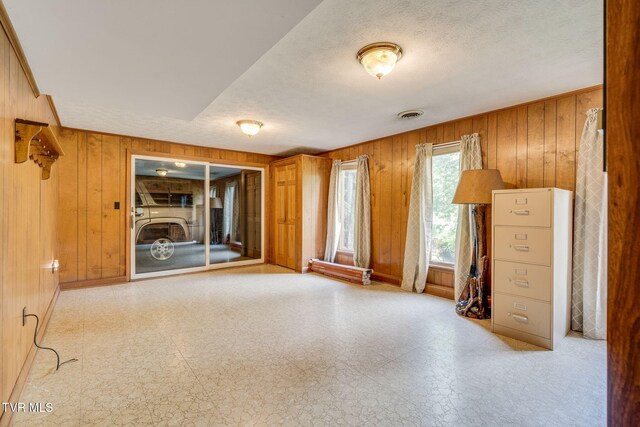 206 Windmere Pl, Kingsport, TN 37663 - spare room featuring wooden walls, tile patterned floors, a textured ceiling, and baseboards