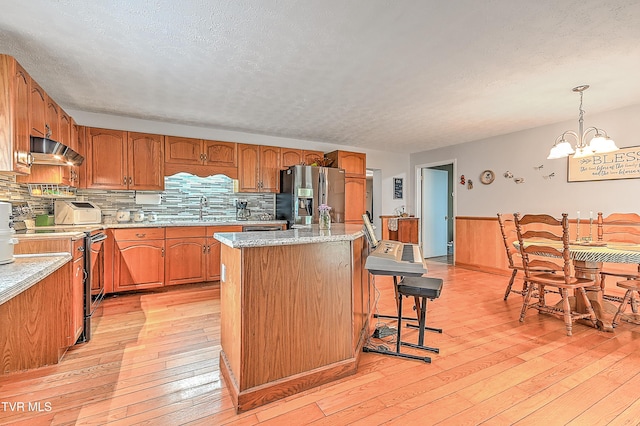 481 Pleasant Hill Rd, Blountville, TN 37617 - kitchen featuring stainless steel appliances, extractor fan, a sink, light wood-style flooring, and a kitchen bar