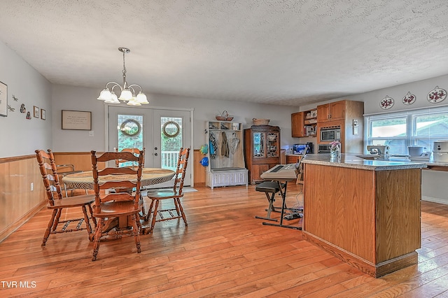 481 Pleasant Hill Rd, Blountville, TN 37617 - dining space with light wood-type flooring, a textured ceiling, a wainscoted wall, and a chandelier