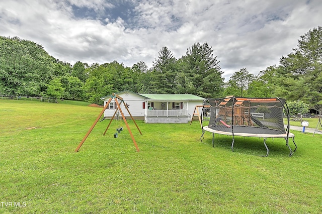 481 Pleasant Hill Rd, Blountville, TN 37617 - view of grassy yard with a trampoline, a playground, and a wooden deck