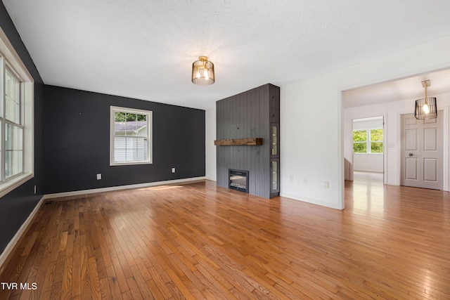 402 Crabtree Rd, Roan Mountain, TN 37687 - unfurnished living room featuring light wood-style flooring, a large fireplace, and baseboards