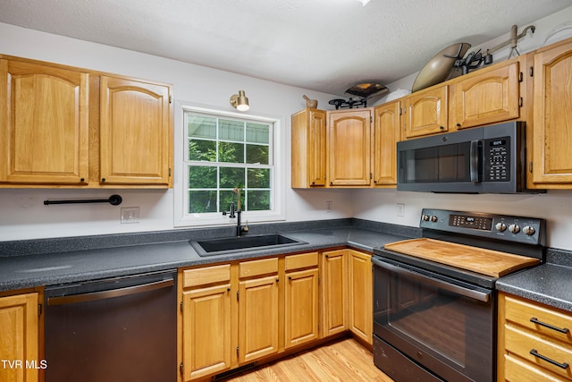 402 Crabtree Rd, Roan Mountain, TN 37687 - kitchen featuring black appliances, a sink, dark countertops, light wood-style flooring, and a textured ceiling