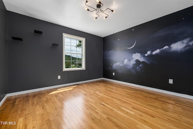 402 Crabtree Rd, Roan Mountain, TN 37687 - unfurnished room with wood-type flooring, baseboards, and a chandelier