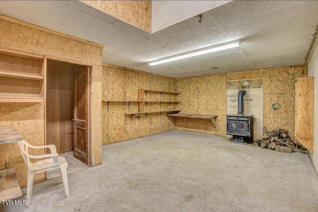 402 Crabtree Rd, Roan Mountain, TN 37687 - unfurnished living room featuring unfinished concrete flooring, a wood stove, and a textured ceiling