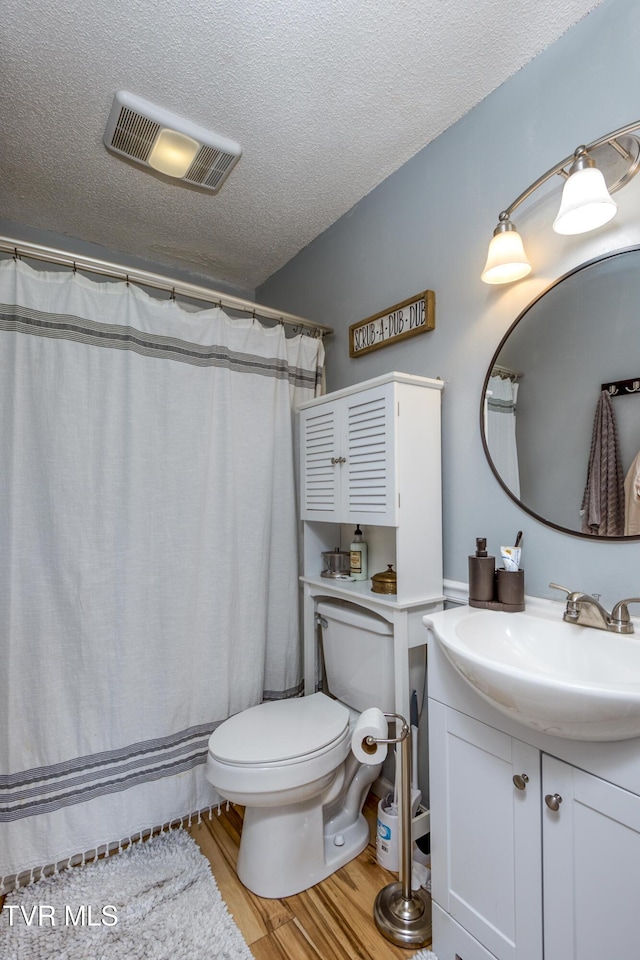 595 Suncrest Dr, Bristol, VA 24201 - full bathroom featuring toilet, vanity, wood finished floors, a textured ceiling, and a shower with shower curtain