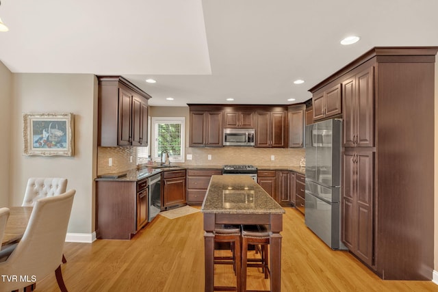 5 Carriage Ct, Johnson City, TN 37604 - kitchen with appliances with stainless steel finishes, a sink, light wood-type flooring, a kitchen island, and stone countertops