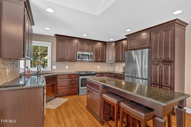 5 Carriage Ct, Johnson City, TN 37604 - kitchen with stainless steel appliances, a sink, light wood-type flooring, dark stone counters, and a kitchen island