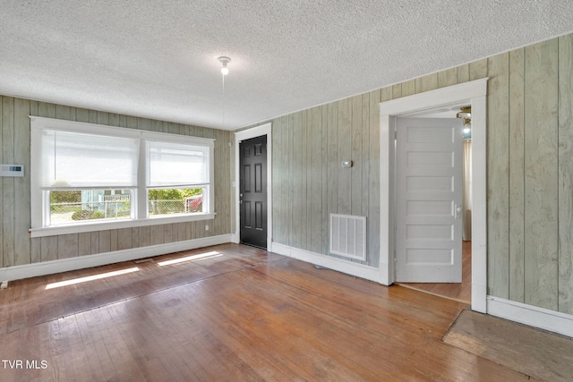 1217 Kentucky Ave, Bristol, TN 37620 - unfurnished room with wood finished floors, wood walls, a textured ceiling, and baseboards
