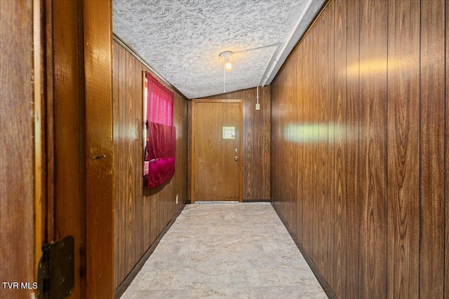 105 Meredith Dr, Elizabethton, TN 37643 - corridor featuring wooden walls, vaulted ceiling, a textured ceiling, and stone finish flooring