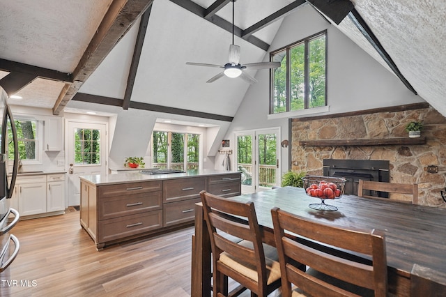 8466 Courtland Rd, Wise, VA 24293 - dining room with high vaulted ceiling, light wood-style flooring, a stone fireplace, healthy amount of natural light, and a ceiling fan