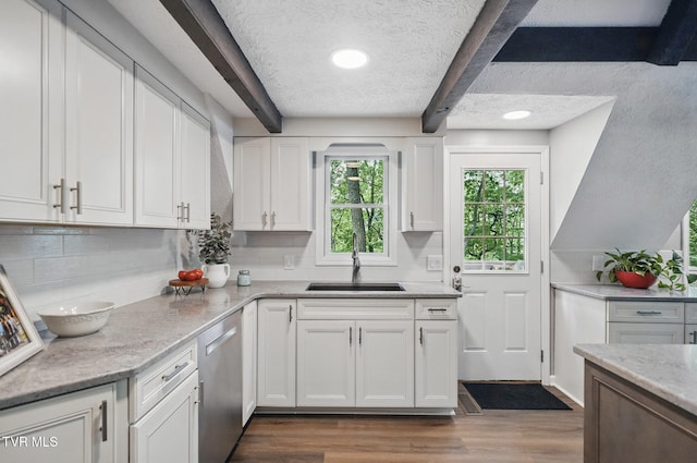 8466 Courtland Rd, Wise, VA 24293 - kitchen featuring a sink, stainless steel dishwasher, beam ceiling, white cabinetry, and decorative backsplash