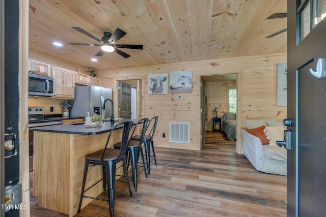 455 Okey Mowell Rd, Kingsport, TN 37660 - kitchen featuring stainless steel appliances, dark countertops, ceiling fan, wooden walls, and light brown cabinetry
