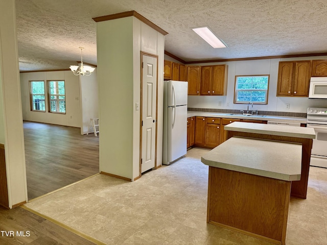 1761 Corby Bridge Rd, Chuckey, TN 37641 - kitchen featuring white appliances, a textured ceiling, brown cabinetry, a chandelier, and a sink