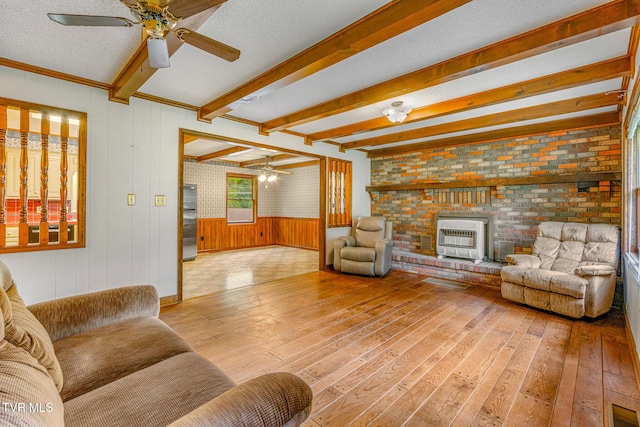 1605 Ryder Church Rd, Bluff City, TN 37618 - living area with heating unit, a ceiling fan, light wood-style flooring, a brick fireplace, and beamed ceiling