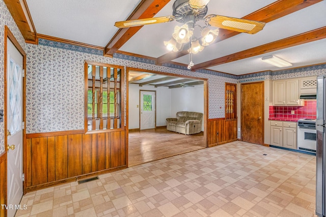 1605 Ryder Church Rd, Bluff City, TN 37618 - kitchen featuring range, wallpapered walls, a ceiling fan, a wainscoted wall, and beamed ceiling
