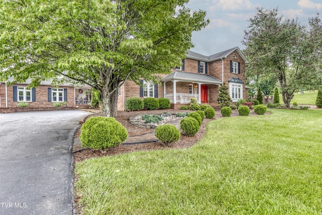 22319 Campground Rd, Bristol, VA 24202 - traditional-style house featuring brick siding, driveway, a front yard, and covered porch