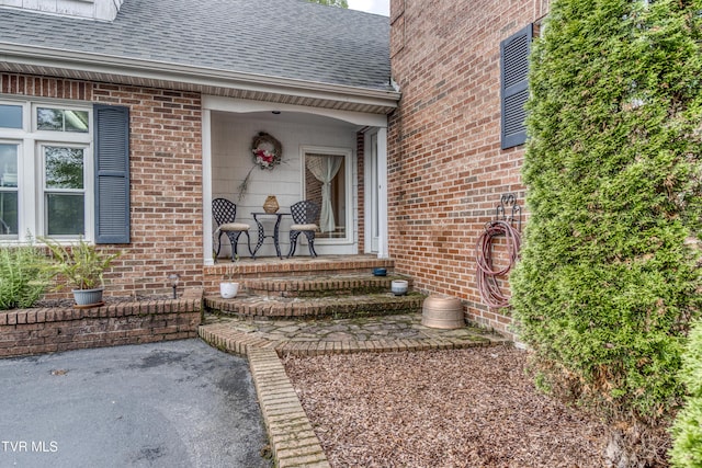 22319 Campground Rd, Bristol, VA 24202 - view of exterior entry featuring a shingled roof, brick siding, and a porch