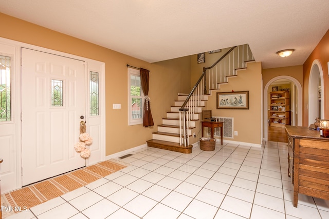 22319 Campground Rd, Bristol, VA 24202 - foyer entrance with baseboards, stairs, arched walkways, and light tile patterned floors