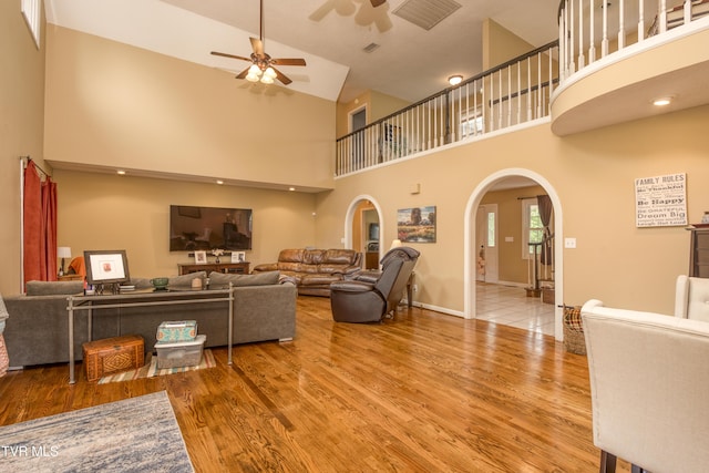 22319 Campground Rd, Bristol, VA 24202 - living room featuring arched walkways, a ceiling fan, a towering ceiling, wood finished floors, and baseboards