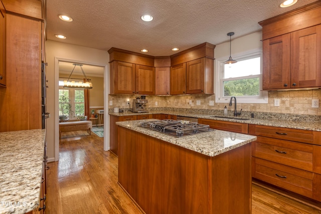 22319 Campground Rd, Bristol, VA 24202 - kitchen featuring a sink, black cooktop, brown cabinetry, light wood finished floors, and a textured ceiling
