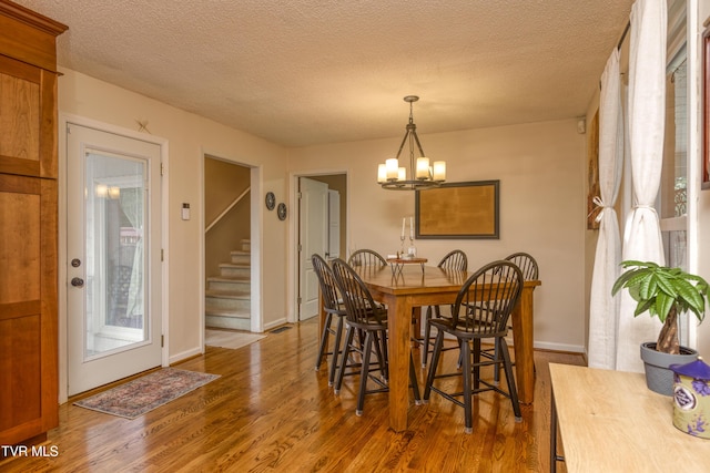 22319 Campground Rd, Bristol, VA 24202 - dining room with wood finished floors, a chandelier, a textured ceiling, stairs, and baseboards