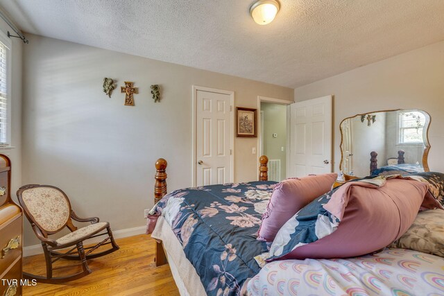 2228 Bruce St, Kingsport, TN 37664 - bedroom with light wood finished floors, a textured ceiling, and baseboards