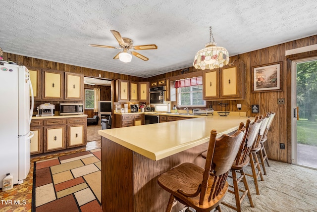 293 Miller Rd, Jonesborough, TN 37659 - kitchen featuring freestanding refrigerator, stainless steel microwave, wood walls, a peninsula, and healthy amount of natural light