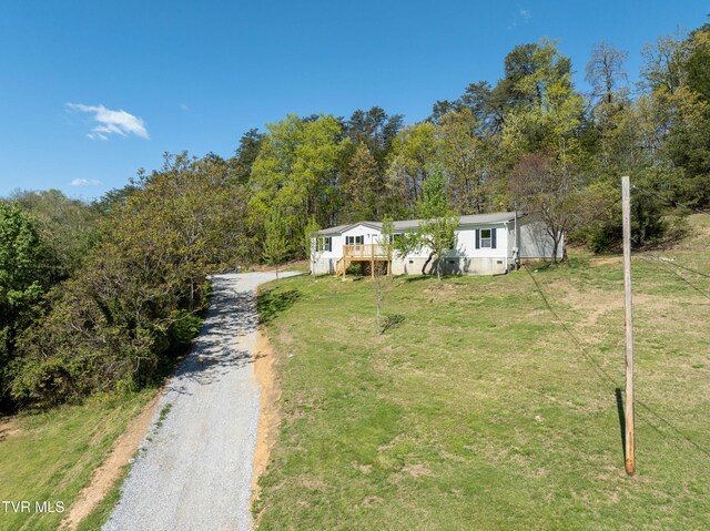 123 Griffin Dr, Dandridge, TN 37725 - view of front of house featuring driveway, a front lawn, a deck, and a view of trees