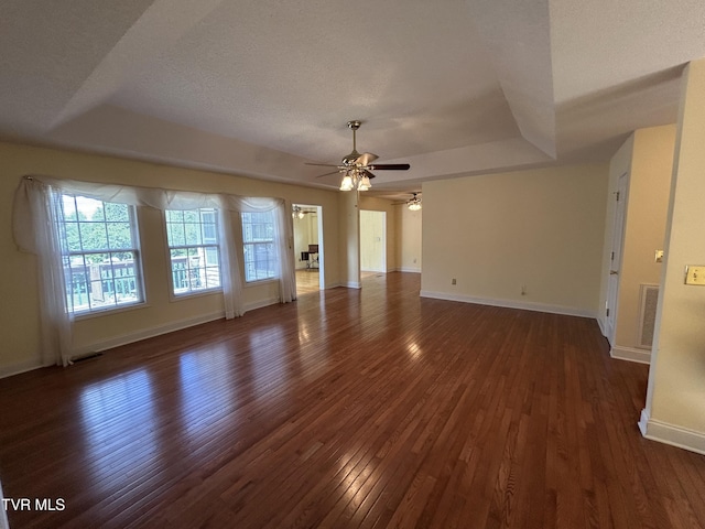 115 Butterfly Ct, Limestone, TN 37681 - unfurnished living room with ceiling fan, dark wood-style floors, a tray ceiling, baseboards, and a textured ceiling