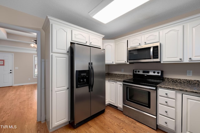 1010 Appaloosa Trl, Johnson City, TN 37604 - kitchen with appliances with stainless steel finishes, white cabinets, light wood finished floors, and a ceiling fan