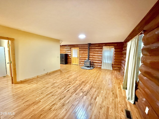 366 Judge Ben Allen Rd, Elizabethton, TN 37643 - unfurnished living room featuring rustic walls, a wood stove, hardwood / wood-style floors, and baseboards