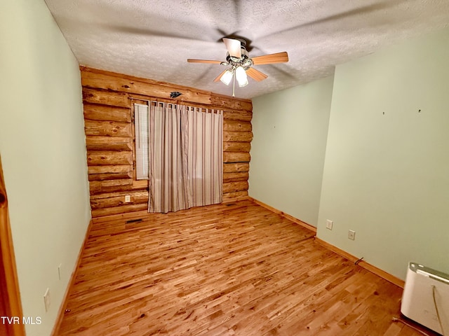 366 Judge Ben Allen Rd, Elizabethton, TN 37643 - empty room with log walls, a textured ceiling, ceiling fan, light wood-type flooring, and baseboards