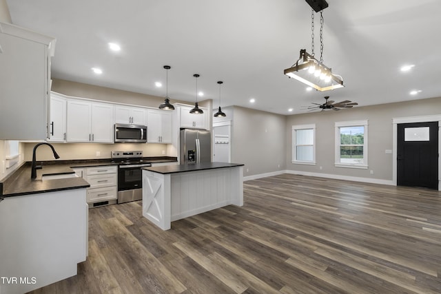 5980 Snapps Ferry Rd, Afton, TN 37616 - kitchen featuring stainless steel appliances, a sink, dark countertops, a kitchen island, and white cabinetry