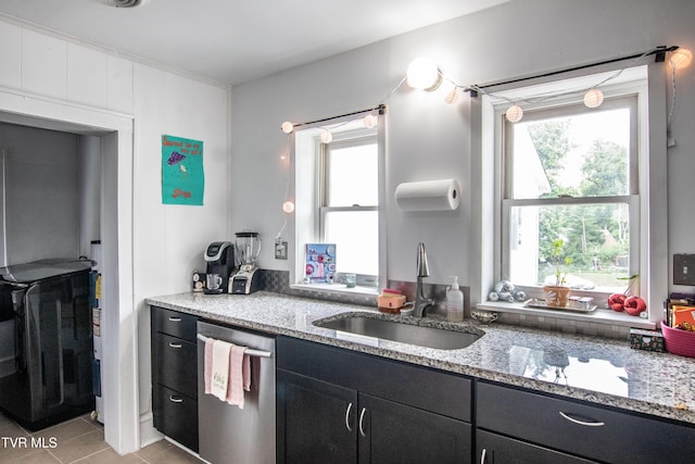 1416 E Cedar St, Bristol, TN 37620 - kitchen featuring stainless steel dishwasher, dark cabinets, a sink, light tile patterned floors, and light stone counters
