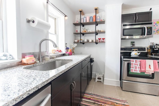 1416 E Cedar St, Bristol, TN 37620 - kitchen featuring appliances with stainless steel finishes, a sink, light tile patterned flooring, light stone countertops, and baseboards