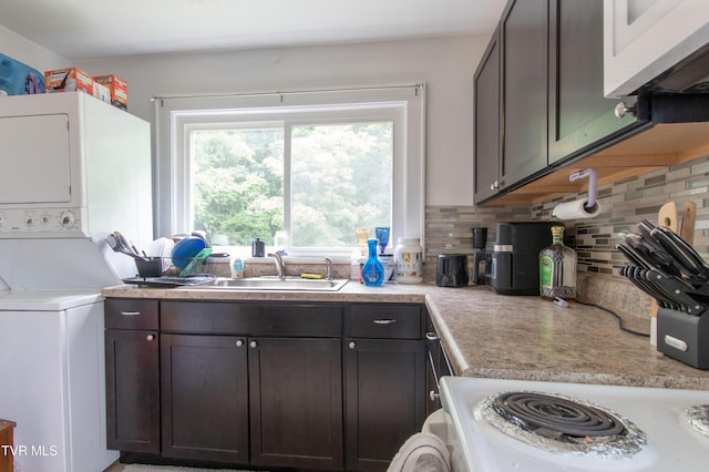 1416 E Cedar St, Bristol, TN 37620 - kitchen featuring stacked washer and clothes dryer, a sink, decorative backsplash, light countertops, and white microwave