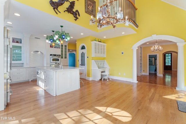133 Knob Creek Dock Rd, Johnson City, TN 37601 - kitchen featuring arched walkways, a chandelier, white cabinetry, light countertops, and a kitchen island with sink